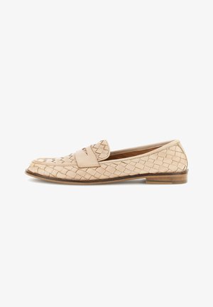 Beige kudottu nahkainen loafer, jossa on litteä puukärki ja koristeellinen hihna yläosassa.