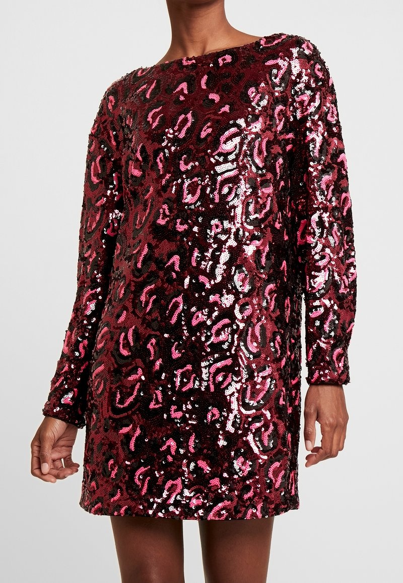 Robe à sequins avec manches longues, présentant un motif léopard en bordeaux, rose et noir. Texture lisse avec une finition brillante.
