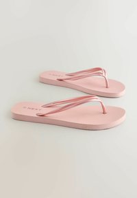 Infradito rosa con una suola testurizzata e cinturini sottili e flessibili. Nome del marchio "NEXT" impresso sulla suola. Design semplice e minimalista.