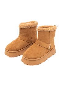 Stivaletti alla caviglia in suede marrone con fodera in pelliccia sintetica, suola piatta in gomma e dettagli con cinturino laterale per una calzata sicura.