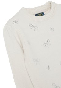 Wit gebreide trui met een gestructureerd ontwerp, versierd met zilveren strik en sterapplicaties. Klassieke ronde halslijn en pofmouwen.