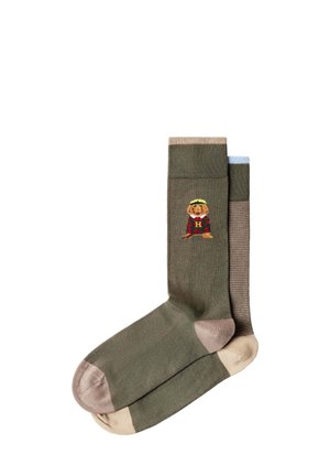 Paar grünlich-brauner Socken mit hellbeiger Ferse und Spitze, eine Socke zeigt einen kleinen bestickten Hund mit rotem Pullover und gelbem Hut.
