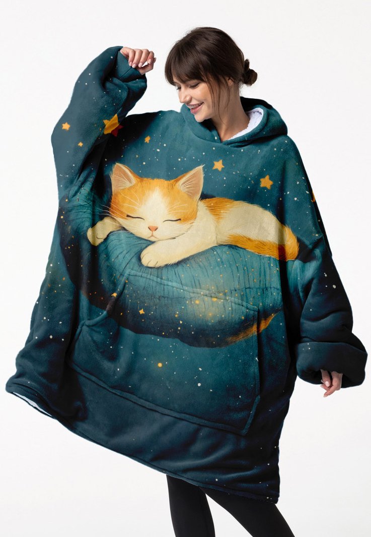 Felpa coperta in pile con design di un gatto che dorme, sfondo blu-verde con stelle e una grande tasca frontale. Fit morbido e oversize.