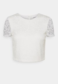 Top corto blanco con cuerpo de encaje floral texturizado y mangas cortas de encaje transparente con patrón. Presenta un escote redondo y cierre de botones en la parte posterior.