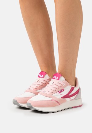 Pink and white sneakers featuring a suede and mesh design, with a padded tongue, lace-up front, and a grey rubber sole.