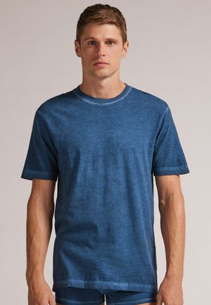 Blaues Baumwoll-T-Shirt mit kurzen Ärmeln, rundem Ausschnitt und lockerer Passform. Verfügt über eine weiche Textur und einen dezenten Wascheffekt. Angepasster Saum.