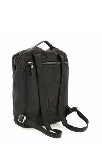 Mochila de cuero negro con correas ajustables, asa superior y múltiples compartimentos con cremallera. Presenta un acabado texturizado y herrajes plateados.