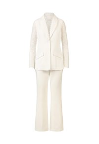 White suit consisting of a tailored blazer with lace long sleeves and a cream-colored pair of flared trousers, featuring pocket details.