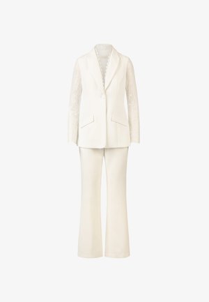 Un costume blanc composé d'un blazer ajusté avec des manches longues en dentelle et d'un pantalon évasé de couleur crème, avec des détails de poches.