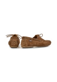 Mocasines de ante marrón con una textura suave, punta redonda estilo mocasín, cierre con cordones y suela de goma con patrones ondulados en el talón.