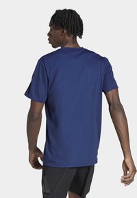 T-shirt de sport bleu marine en tissu évacuant l'humidité, à manches courtes, col rond, motif texturé subtil, construction légère.