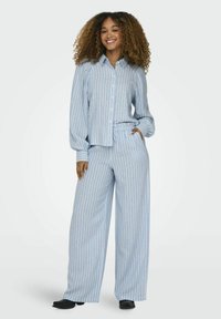 Set de loungewear în dungi albastre și albe, format dintr-o cămașă cu nasturi, cu mâneci lungi, și pantaloni cu picioare largi, având un tiv elastic.