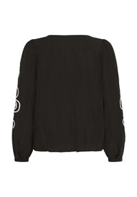 Blouse noire à manches longues avec des manches bouffantes et une broderie florale blanche sur les bras extérieurs, poignets à boutons et ourlet droit.