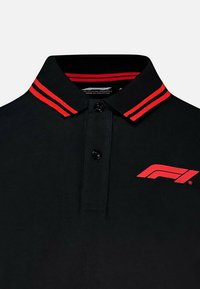 Czarna koszulka polo z czerwonymi podwójnymi paskami na kołnierzyku oraz czerwonym logo "F1" na lewej piersi, zapięcie na dwa czarne guziki.