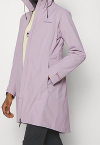 Light purple waterproof jacket with a zip front, adjustable hood, and side pockets; features smooth texture and a relaxed fit.