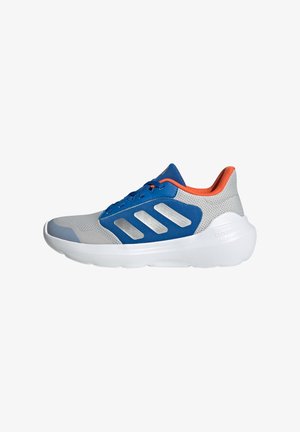 Sneakers sportivi con tomaia in mesh grigia, dettagli blu, strisce riflettenti argento e un linguetta arancione sul tallone. Presentano una suola bianca imbotita.