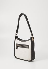 Czarna i biała torba na ramię z teksturowanym materiałem, gładkimi skórzanymi detalami oraz przednią kieszenią na zamek błyskawiczny z metalowym suwakiem.
