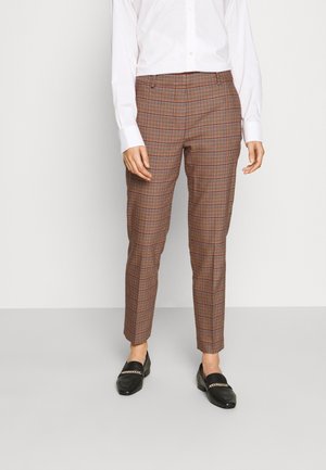 Pantalons à carreaux marron avec une coupe ajustée, présentant une texture subtile, deux poches avant et une taille lisse. Assortis à des mocassins noirs.