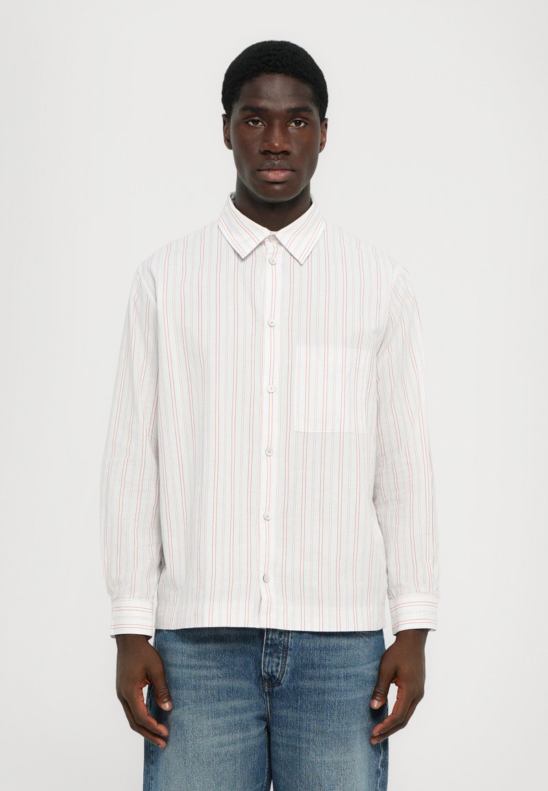 Chemise blanche à manches longues avec des rayures rouges et bleu clair, col boutonné, poche poitrine unique et coupe décontractée. Tissu léger.