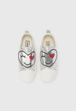 Chaussures argentées pour enfants à enfiler avec des bouts blancs, chacune affichant un visage de cœur souriant et un cœur rouge près de l’œil.