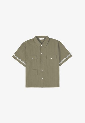Kortærmet olivengrøn skjorte med lodrette striber, to forlommer og hvid blomsterbroderi på ærmerne. Knappesystem.