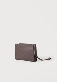 Σκούρο γκρι υφασμένο δερμάτινο πορτοφόλι με φερμουάρ και λουράκι καρπού σε απλό λευκό φόντο, σε γωνία που δείχνει το μπροστινό και το πλάι.