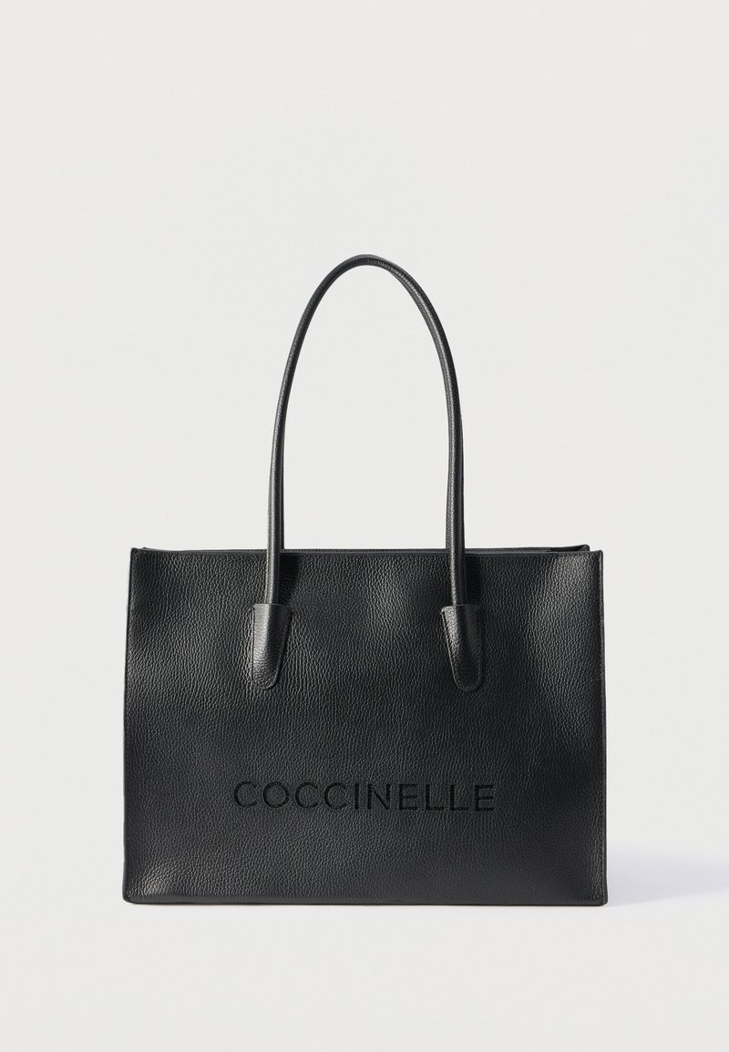 Μαύρη δερμάτινη τσάντα ώμου με μακριές λαβές και ανάγλυφο λογότυπο "COCCINELLE" μπροστά, τοποθετημένη σε απλό ανοιχτό φόντο.