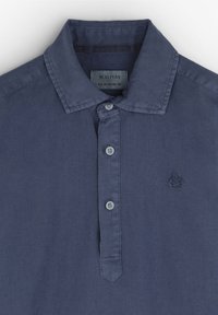 Dunkelblaues Poloshirt aus Baumwolle mit spitzem Kragen, drei Knöpfen und einem gestickten Totenkopf-Logo auf der linken Brust.