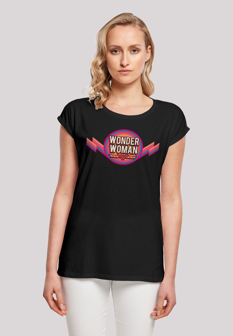 Svart bomullst-skjorte med et fargerikt "WONDER WOMAN"-grafikk med sirkulært design og vinklede detaljer i rødt og rosa. Korte ermer.