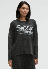 Black long-sleeve sweatshirt with a high-low hem and white graphic text on the front. Made from a textured fabric for a soft appearance.