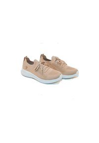Baskets de sport en tricot beige avec semelles blanches, présentant un dessus texturé, un design à lacets et un logo subtil sur le côté.