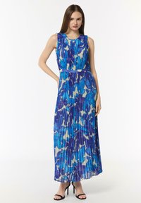 Maxi sukienka wykonana z plisowanej tkaniny w niebieskich odcieniach z kremowym abstrakcyjnym wzorem. Bez ramiączek, dopasowana w talii z rozkloszowanym dołem.