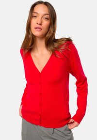 Rote Strickjacke mit V-Ausschnitt, langen Ärmeln und vorderem Knopfverschluss. Weicher Stoff und taillierte Form. Mit gerippten Bündchen und Saum.