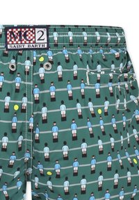Pantaloni da bagno in tessuto verde con un motivo ripetuto di figure stilizzate in azzurro chiaro e bianco, con pantaloni neri e dettagli in giallo.