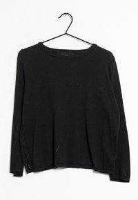 Schwarzer Pullover mit langen Ärmeln und rundem Halsausschnitt, mit einem Spitzenakzent auf der linken Seite, aus einem weichen, strukturierten Material.