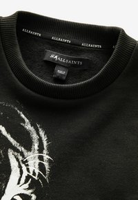 Sudadera negra de tela suave con cuello redondo acanalado. Presenta un estampado gráfico en la parte delantera. La etiqueta muestra "ALLSAINTS", hecha en Turquía.