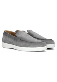 Chaussures à enfiler en suède gris avec une semelle en caoutchouc blanche contrastante, présentant des détails cousus le long de l'orteil et un design épuré et linéaire.