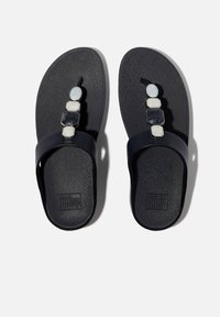 Sandalo nero con una soletta texturizzata, dotato di una cinghia liscia e di un'ornamentazione decorativa con pietre geometriche bianche e grigie.