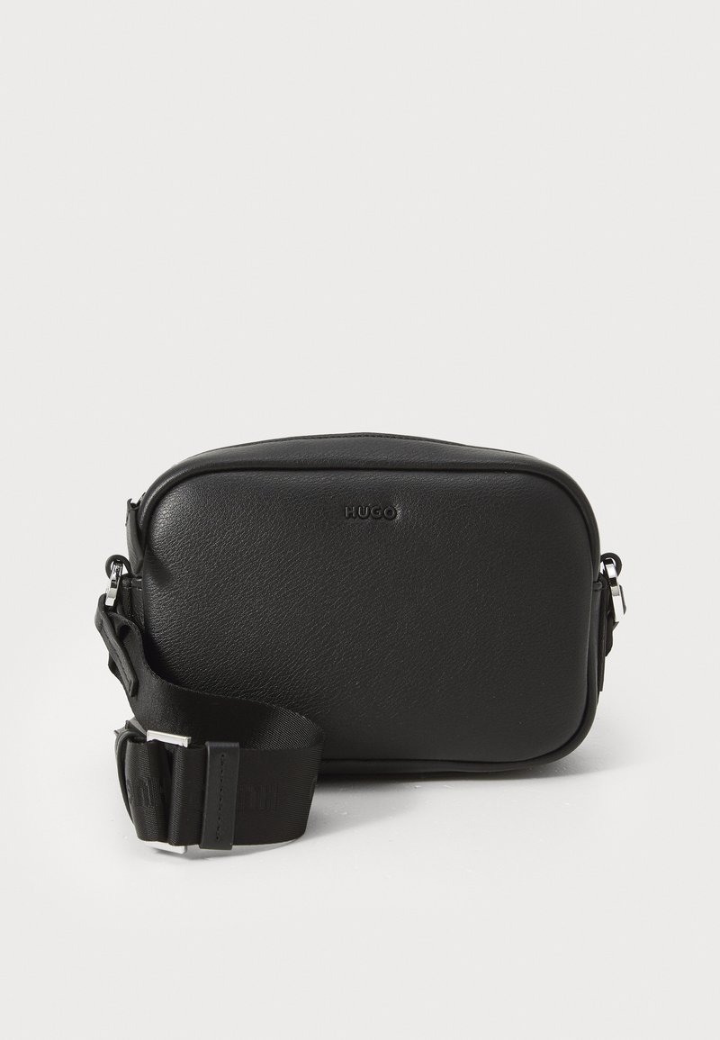 Borsa a tracolla nera in pelle con una superficie liscia, forma rettangolare, chiusura con zip e tracolla regolabile con marchio inciso.