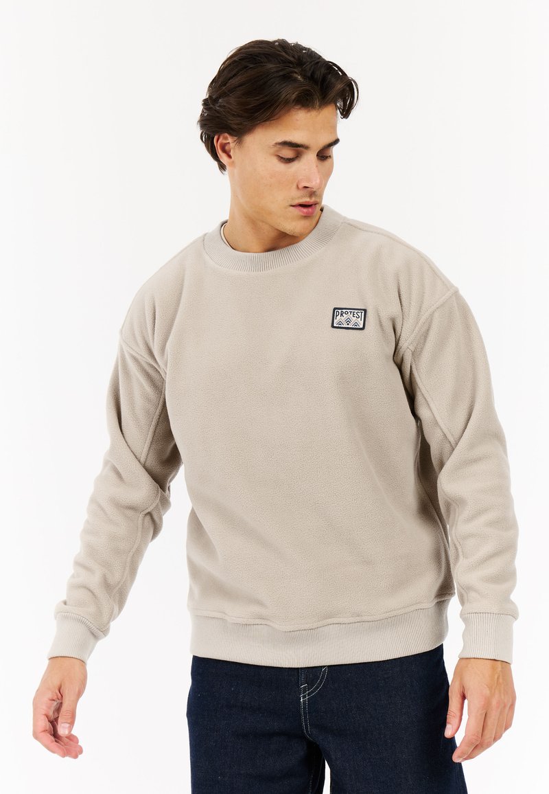 Beige fleece sweatshirt met ronde hals en geribde manchetten. Kenmerkt zich door een klein geborduurd logo op de borst en een relaxte pasvorm.