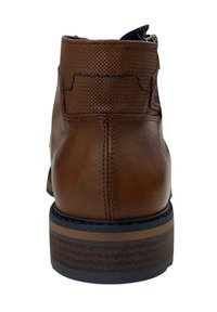 Bruine leren enkelboot met een gestructureerde bovenkant, voorzien van een decoratieve naad en een gestapelde hak met contrasterende lagen.