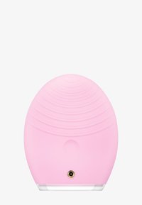 Rosa silikonrenseapparat, oval form med teksturerte riller, en sirkulær knapp og en liten gulltilkoblingsport nederst.