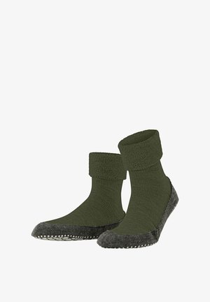 Calze verdi lavorate a maglia con polsino testurizzato e suole in feltro grigio. Le suole presentano un motivo a pois per una migliore aderenza.