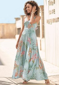 Blumenmuster langes Kleid aus hellblauem Stoff, mit lebhaften pinken und grünen Mustern, dünnen Trägern und einer fließenden Silhouette.