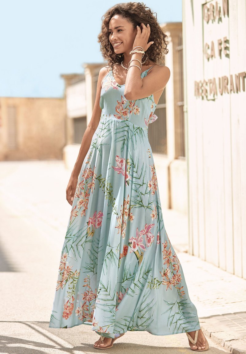 Blumenmuster langes Kleid aus hellblauem Stoff, mit lebhaften pinken und grünen Mustern, dünnen Trägern und einer fließenden Silhouette.