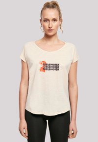 Light beige, short-sleeve t-shirt with a round neckline. Features a graphic print in orange and dark purple text, with a slightly curved hem.