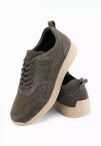 Sneakers in suede verde oliva con finitura testurizzata, dettagli perforati e suola in gomma di colore chiaro. Presentano un design con lacci e linguette di tiraggio.