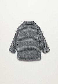 Áčková bunda v černobílé, s límcem a dlouhými rukávy. Vyrobena z texturovaného materiálu se viditelným mřížkovým vzorem a širokým střihem.