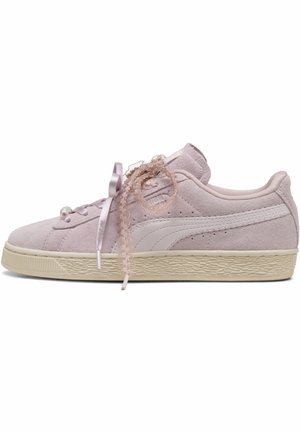Zapatilla Puma de ante rosa claro con suela de goma color crema, cinta de satén y cordones con lazada, y detalles perforados sutiles en el lateral.