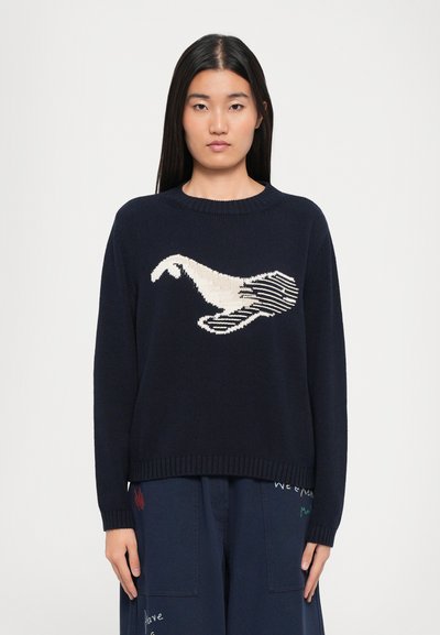 Pull en tricot bleu marine avec un motif graphique crème et noir représentant un oiseau. Présente un col rond et un ourlet côtelé. Épaisseur moyenne.